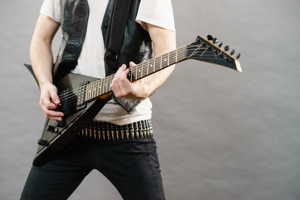 Unrecognizable hardcore man wearing metal outfit playing on electric guitar heavy rock music. - Fotoğraf, Görsel