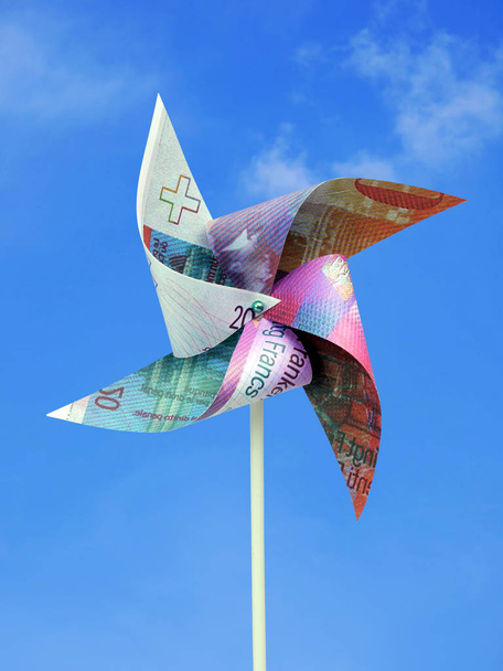 Billet de 20 francs suisses coupé en jouet moulin à vent tourné sur le ciel bleu
 - Photo, image