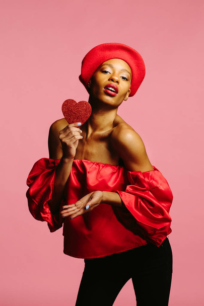 attraente giovane donna in rosso in possesso di un cuore rosso, essere il mio San Valentino
 - Foto, immagini