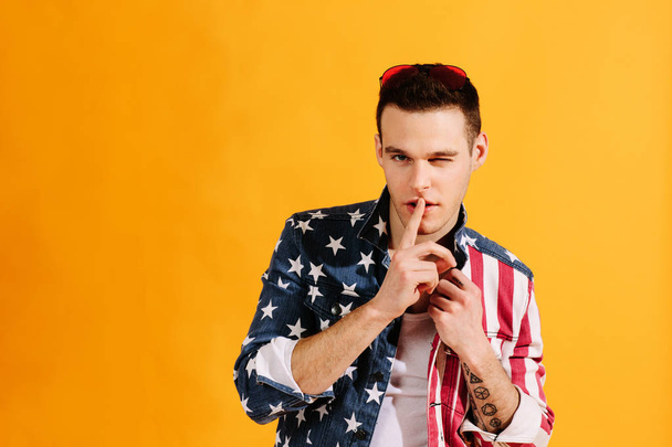 Симпатичний хлопець з пальцем на рот і одним оком підморгує в американському джеку прапорі
 - Фото, зображення