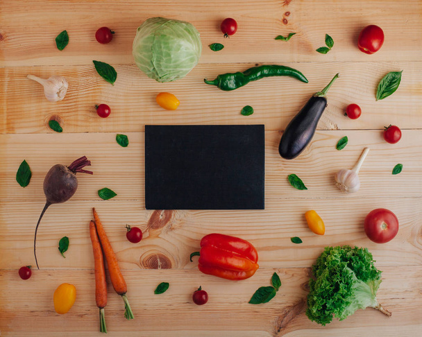 Top view of wooden background with copy space and fresh vegetables - Photo, Image