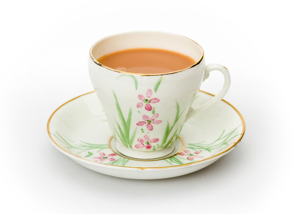 thee in een hand painted kop en schotel - Foto, afbeelding