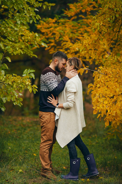 Young couple stands and embraces during walk in autumn forest. - Photo, Image