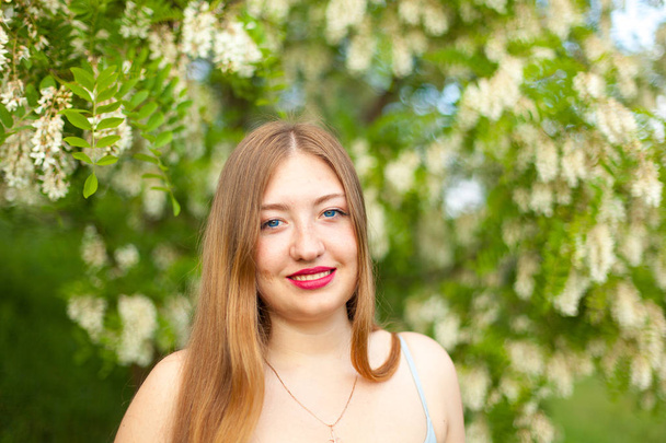 bir kız uzun saçlı artı boyutu şekil çiçekleri akasya yeşil bahar çayır üzerinde çevrili portresi - Fotoğraf, Görsel
