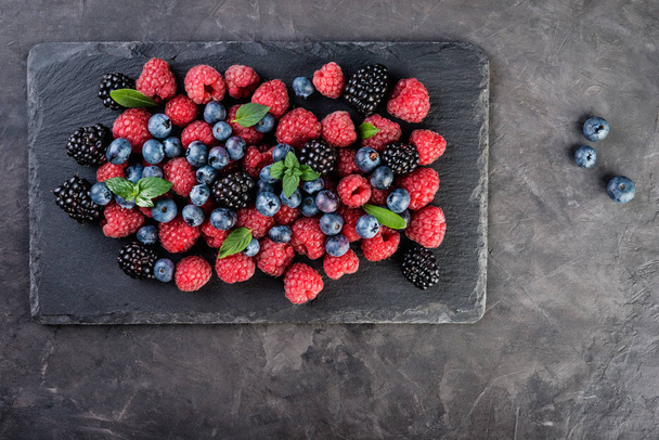 Свіжі ягоди на темному тлі, копійка, вид зверху, концепція здорової їжі
 - Фото, зображення