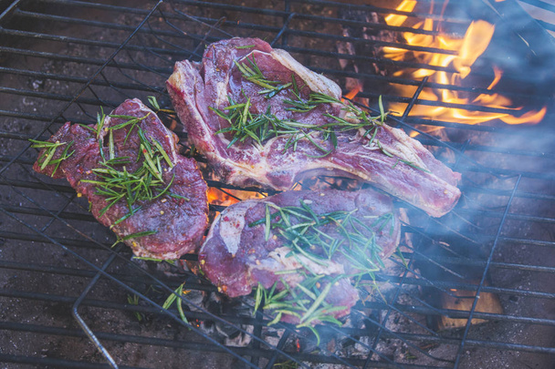 Raw meat on the grill, sprinkled with thyme. Cooking food - Photo, Image