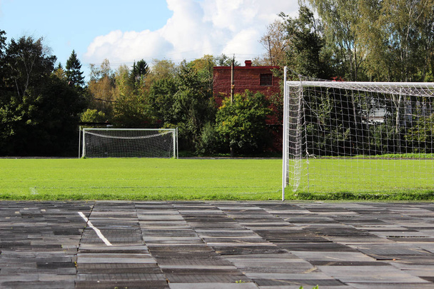 stadium: a treadmill with rubber plates and a football field with a goalkeeper's goals - Photo, Image