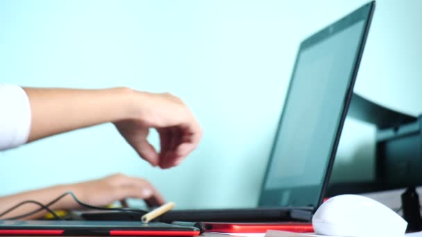 Close-up. Meisje teken op een grafisch tablet. Freelance. Een hand met een stylus verplaatsen op een rood zwart tablet. 4k, slow-motion. kleur achtergrond. kopie ruimte - Video