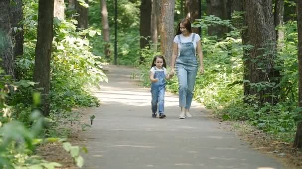 Family concept. Young mother and child daughter holding hands and walk - Footage, Video