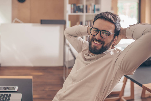 Usměvavý mladý muž s brýlemi v coworkingu - Fotografie, Obrázek