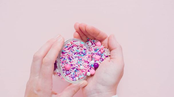Colorful purple sprinkle blend on a pink background. - Foto, afbeelding
