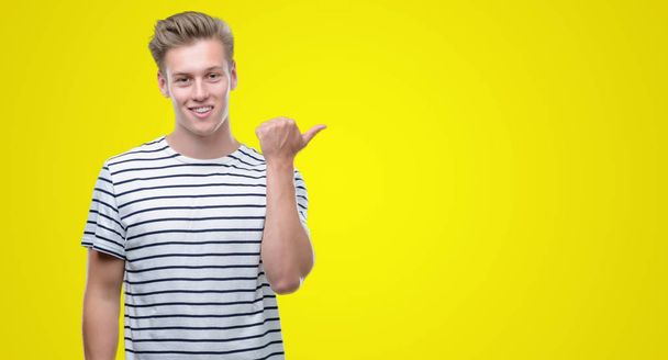 Młody przystojny blond człowiek sobie paski żeglarz t-shirt góry z dłoni i palców z szczęśliwy twarz uśmiechający się - Zdjęcie, obraz