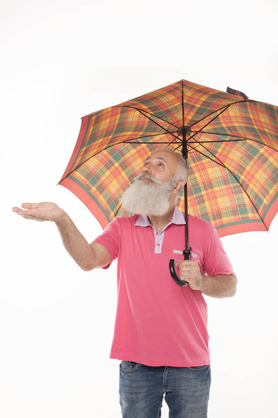 business protection concept senior man with umbrella feeling for rain - Фото, зображення