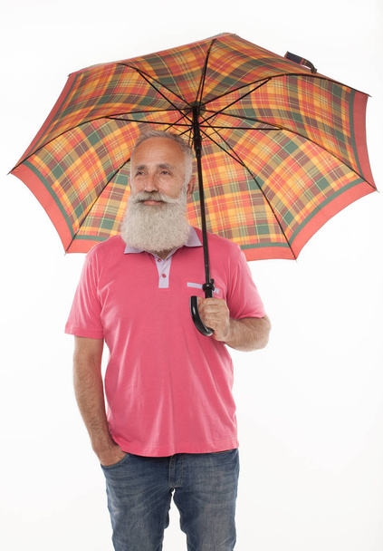 business protection concept senior man with umbrella feeling for rain - Foto, afbeelding