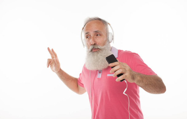 Enjoying the sound of music. Studio portrait of handsome senior man with beard and headphones. - Fotó, kép