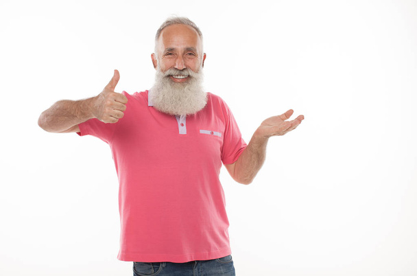 Happy smiling senior bearded man holding something imaginary in  hand. - Photo, Image