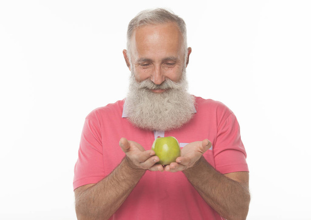 Healthy senior bearded man about to enjoy a fresh apple. Studio shot on white background. Plenty of copy space. - Photo, Image
