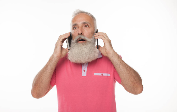 Heated discussion. White-haired old man having a conversation on the phone and gesticulating emotionally while posing isolated on a white background - Photo, Image