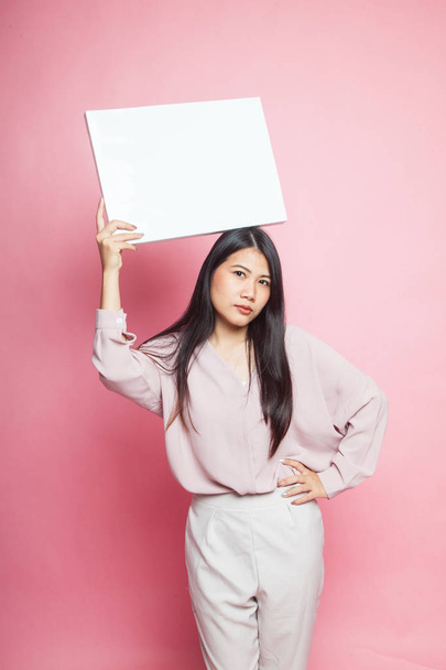 Young Asian woman with white blank sign on pink background - Fotó, kép