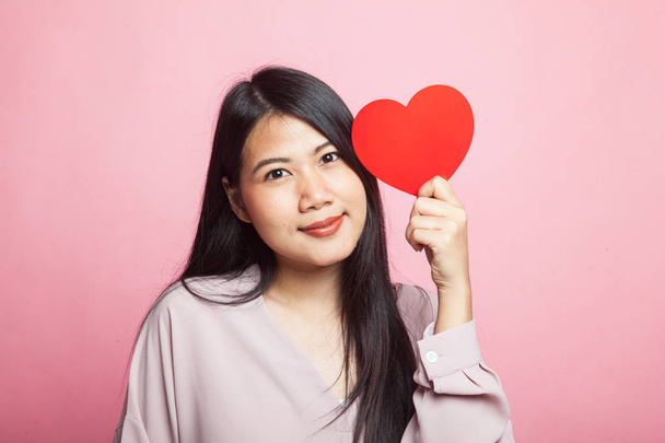 Asian woman with red heart on pink background - Foto, imagen