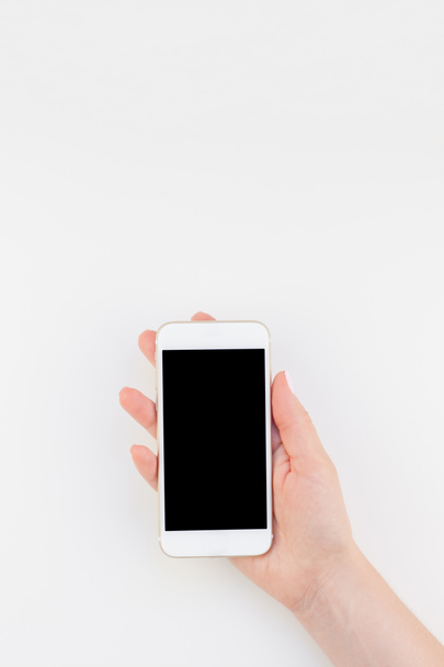 Main de femme avec vernis à manucure pastel tenant smartphone isolé sur fond blanc avec espace de copie dans un style minimaliste. Modèle de maquette pour blog féminin médias sociaux technologiques
 - Photo, image
