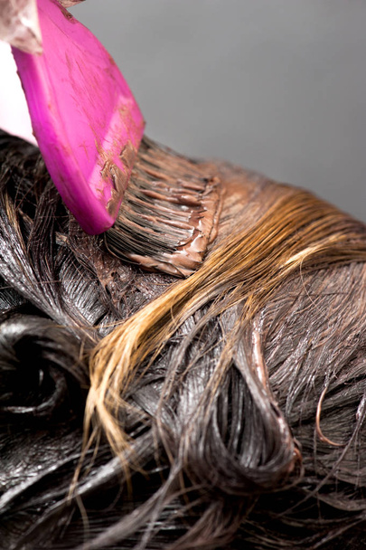 Μια ριζική αλλαγή του χρώματος των μαλλιών. Ξανθιά γυναίκα master βάζει χρώμα στα μαλλιά της - Φωτογραφία, εικόνα
