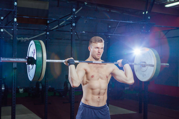Muscular fitness man preparing to deadlift a barbell over his head in modern fitness center.Functional training.Snatch exercise. Cross style fit, deadlift - Foto, Imagem
