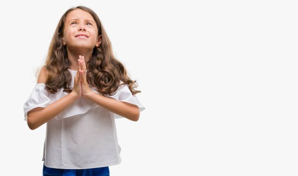 Μελαχρινή κορίτσι Ισπανόφωνος επαιτεία και προσεύχεται με τα χέρια μαζί με ελπίδα έκφραση προσώπου πολύ συναισθηματική και ανησυχούν. Ζητώντας συγχώρεση. Έννοια της θρησκείας. - Φωτογραφία, εικόνα