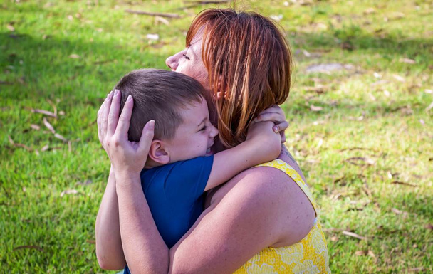 Jovem mãe branca e seu filho bonito abraçando uns aos outros
. - Foto, Imagem