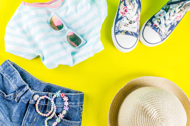 Летние каникулы концепция, набор ткани для летнего ребенка - детские шорты, футболки, шляпа, солнцезащитные очки, браслет ожерелье, кроссовки, ярко-желтый фон над плоским копировать пространство
 - Фото, изображение