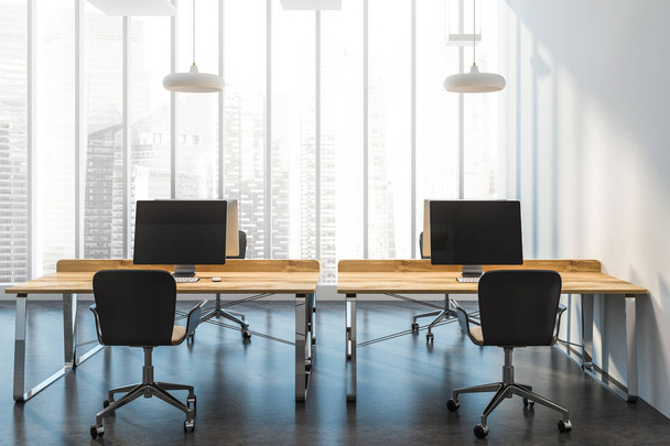 Interior of a modern consulting company office with panoramic windows with a city view, a concrete floor and wooden computer desks standing in a row. 3d rendering mock up - Фото, изображение