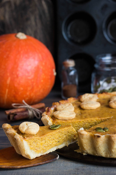 Traditional American pumpkin pie for a holiday on a dark wooden background - Fotoğraf, Görsel