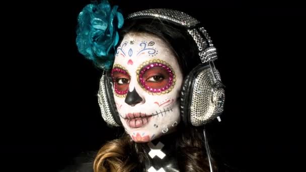 mooie vrouw met aangepaste ontworpen snoep schedel Mexicaanse dag van de dode gezicht make-up op zwarte achtergrond - Video