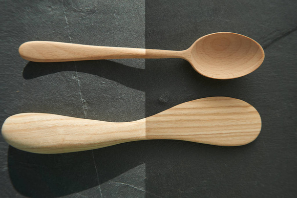Primer plano de una cuchara de madera y un utensilio de cocina rústico como concepto para la simplicidad o la cocina simple
 - Foto, Imagen
