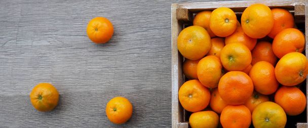 Fresh tangerines in an old box . On wooden background. Free space for text . - Photo, Image