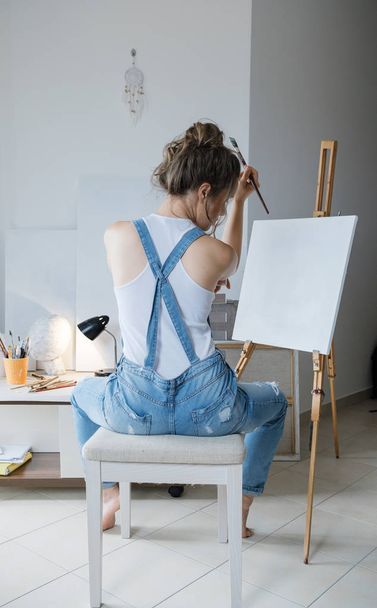 In search of inspiration. Sad Woman painter in front of the canvas and drawing. Artist studio interior. Process in art workshop. - Foto, Imagem