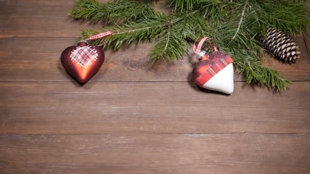 Briefkaart voor Nieuwjaar en Kerstmis. Sneeuw vallen op de kerstboom decoratie geplaatst op houten achtergrond. Bovenaanzicht - Video
