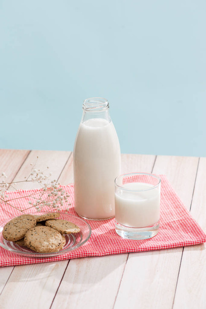 Pastry organic breakfast. Chip cookies and a glass of milk on a white wooden table. - Photo, Image