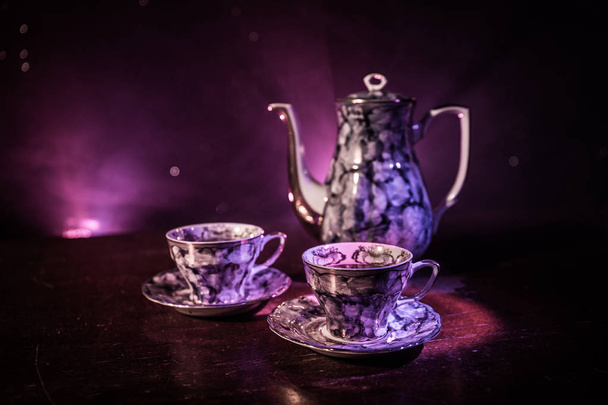 コーヒーやお茶のコンセプト テーマです。古いビンテージ セラミックお茶や光と煙で暗いトーンの背景にはカップとコーヒー ポット。本文の空白。選択と集中 - 写真・画像