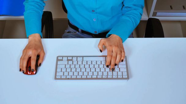 vue de dessus femme méconnaissable jouant jeu d'ordinateur assis à l'espace de travail de bureau blanc
 - Photo, image