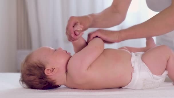 Mother giving a massage for her infant baby - Materiaali, video