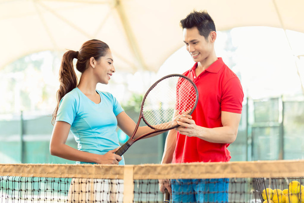 Tennislehrer bringt Anfängern den richtigen Griff bei - Foto, Bild