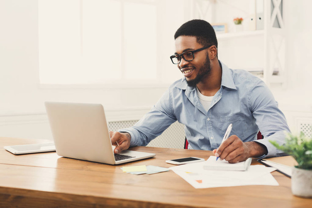 Jeune homme d'affaires noir travaillant avec un ordinateur portable
 - Photo, image