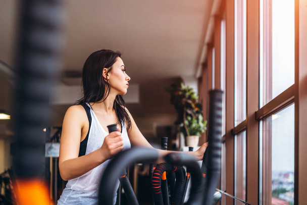 Woman training on ellipsoidal machine in gym. - Foto, Imagem