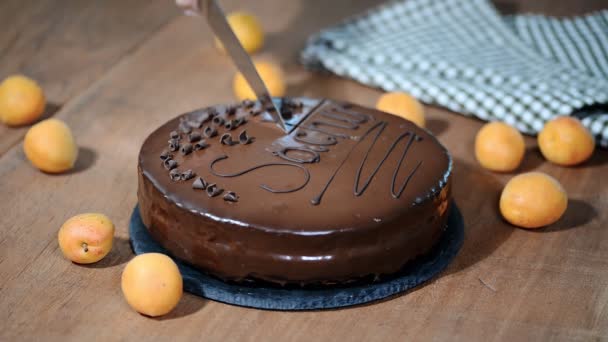 Egy nő vágás egy csokoládé Sacher torta. - Felvétel, videó
