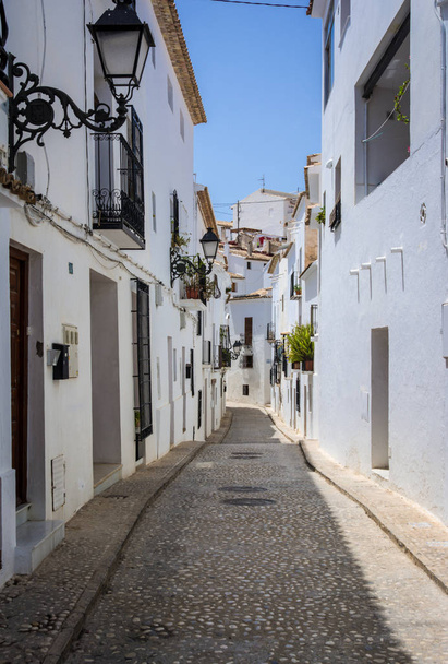Rua estreita pitoresca com casas brancas na aldeia de Altea, Alicante, Espanha. Conceito de viagem e férias. Altea é uma cidade mediterrânea no coração da Costa Blanca
 - Foto, Imagem