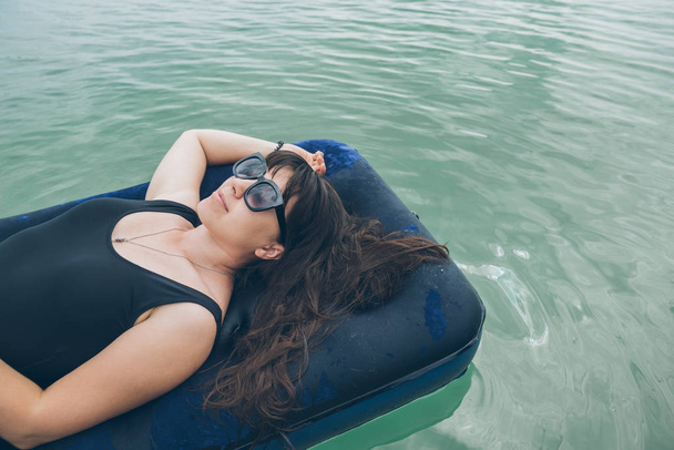 donna sul materasso nuotare in acqua azzurra. concetto di ora legale
 - Foto, immagini