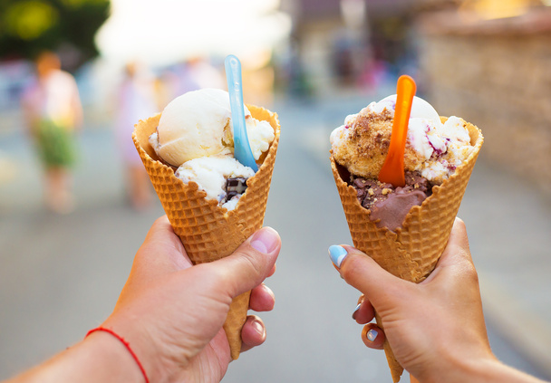 Hermoso helado brillante con diferentes sabores en las manos de una pareja - Foto, Imagen
