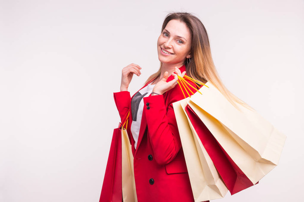 Portrait of happy woman in red suit with shopping bags with copy space. - Fotografie, Obrázek