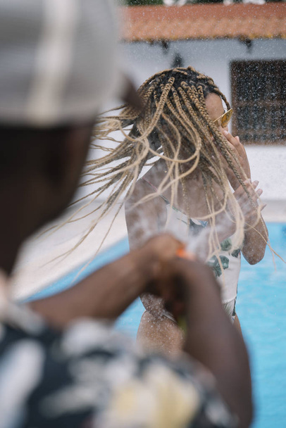 Donna latina con occhiali gialli gioca con acqua in piscina
 - Foto, immagini